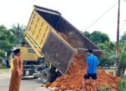 Kepala Sekolah SD Negeri 118194 Romauli Samosir menerima bantuan tanah timbunan dari Kasat Narkoba Polres Labuhan Batu AKP Hardiyanto di halaman sekolah