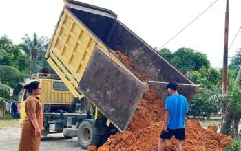 Kepala Sekolah SD Negeri 118194 Romauli Samosir menerima bantuan tanah timbunan dari Kasat Narkoba Polres Labuhan Batu AKP Hardiyanto di halaman sekolah
