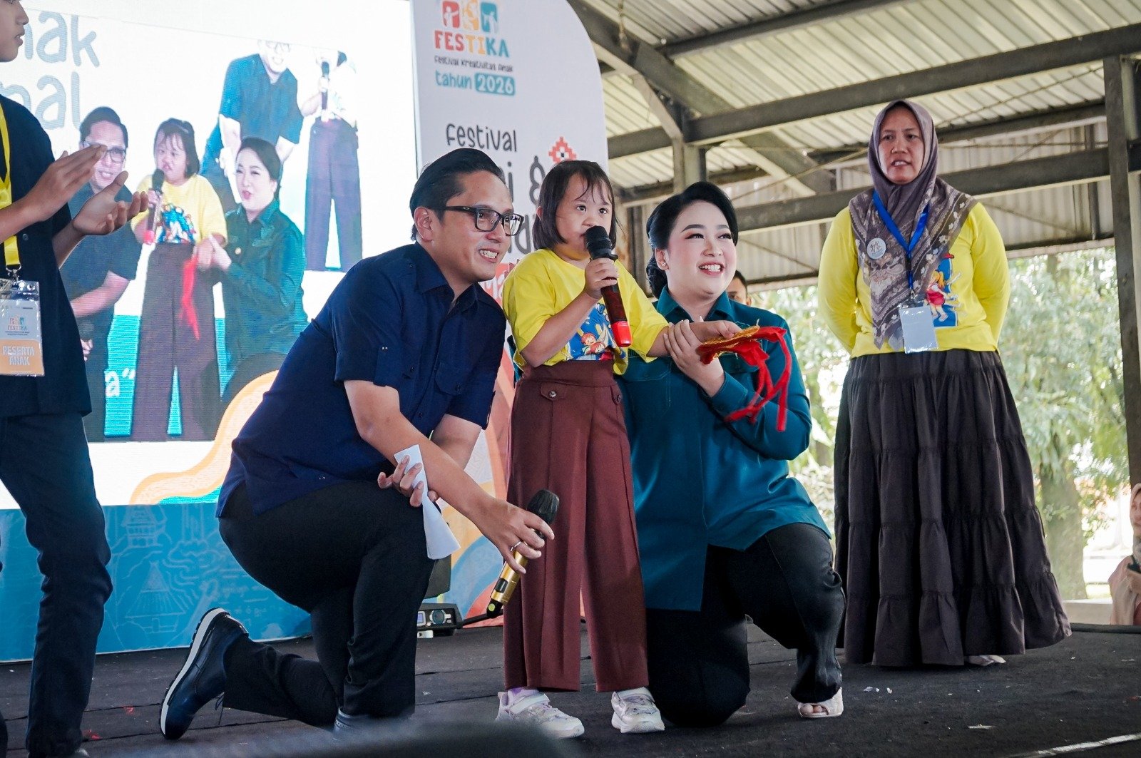 Kiran anak penyandang down syndrome bernyanyi di atas panggung bersama Wali Kota Medan Rico Waas dalam peringatan Hari Anak Nasional 2026 di Gedung Pancasila USU
