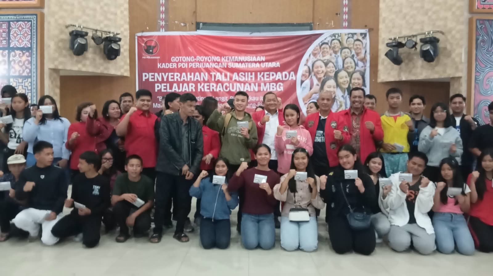 Rapidin Simbolon menyerahkan bantuan tabungan kepada pelajar korban keracunan MBG di Karo