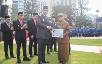 Rico Waas menyerahkan penghargaan kepada Kepling Lingkungan 3 Harjosari II